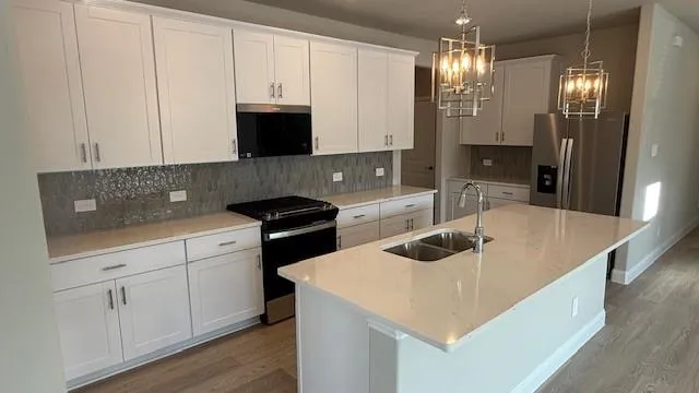 a kitchen with granite countertop white cabinets and stainless steel appliances