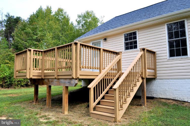 2220 Partlow Road Beaverdam, VA 23015 - Photo 22 of 24 a view of a house with wooden deck and furniture
