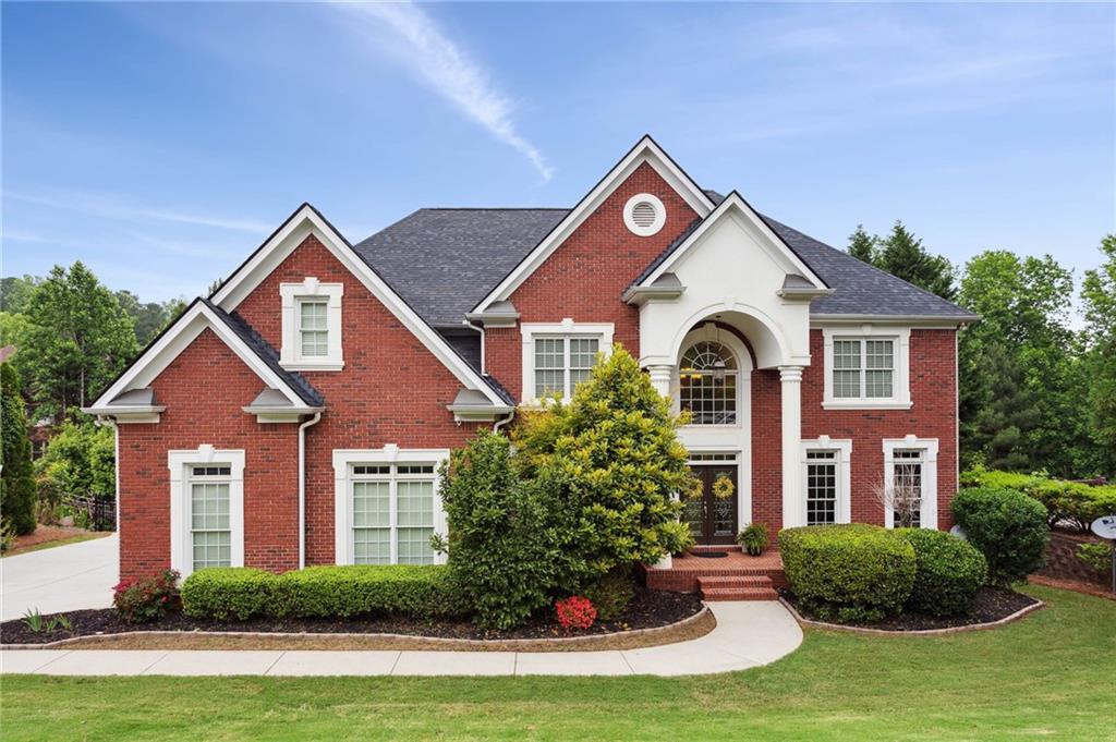 1021 Heathchase Drive Suwanee, GA 30024 - Photo 1 of 1 a front view of a house with a yard and garage
