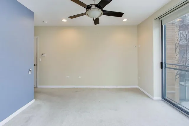a view of a room with a ceiling fan and window