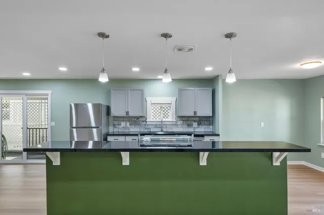 a view of kitchen with kitchen island and stainless steel appliances