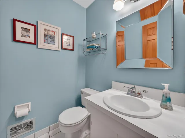 a bathroom with a toilet a sink and mirror