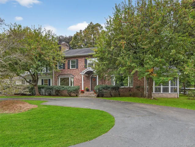 a front view of house with yard and green space