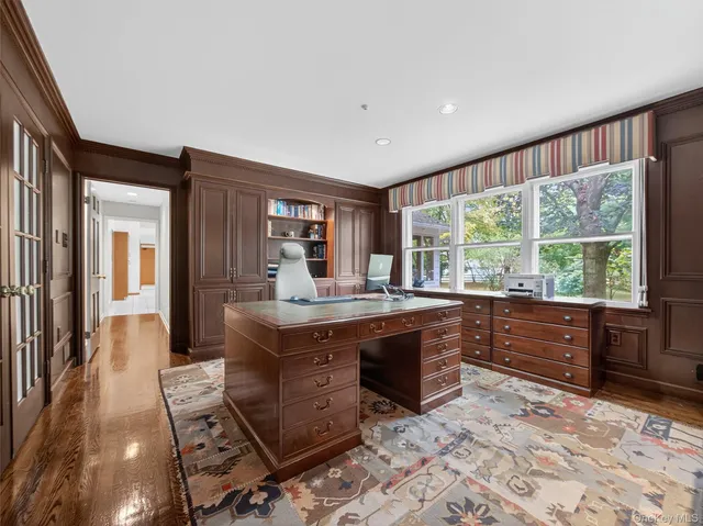 a large kitchen with stainless steel appliances granite countertop a stove a sink dishwasher and a large mirror with wooden floor