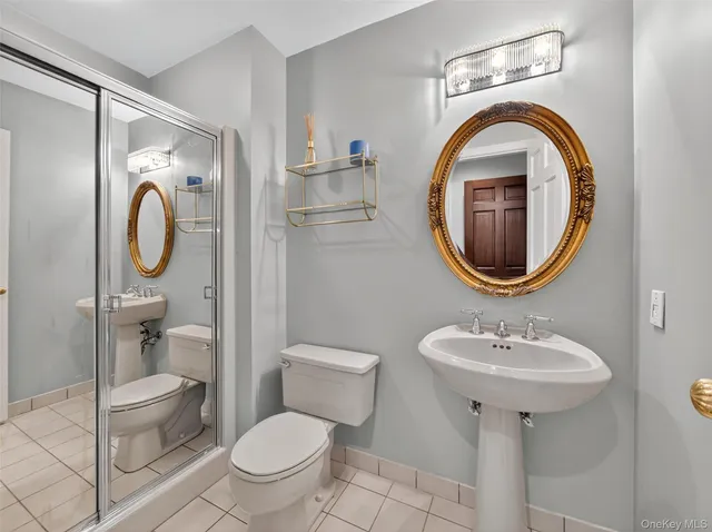 a bathroom with a toilet sink and a mirror