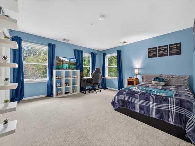 a spacious bedroom with a bed and large windows