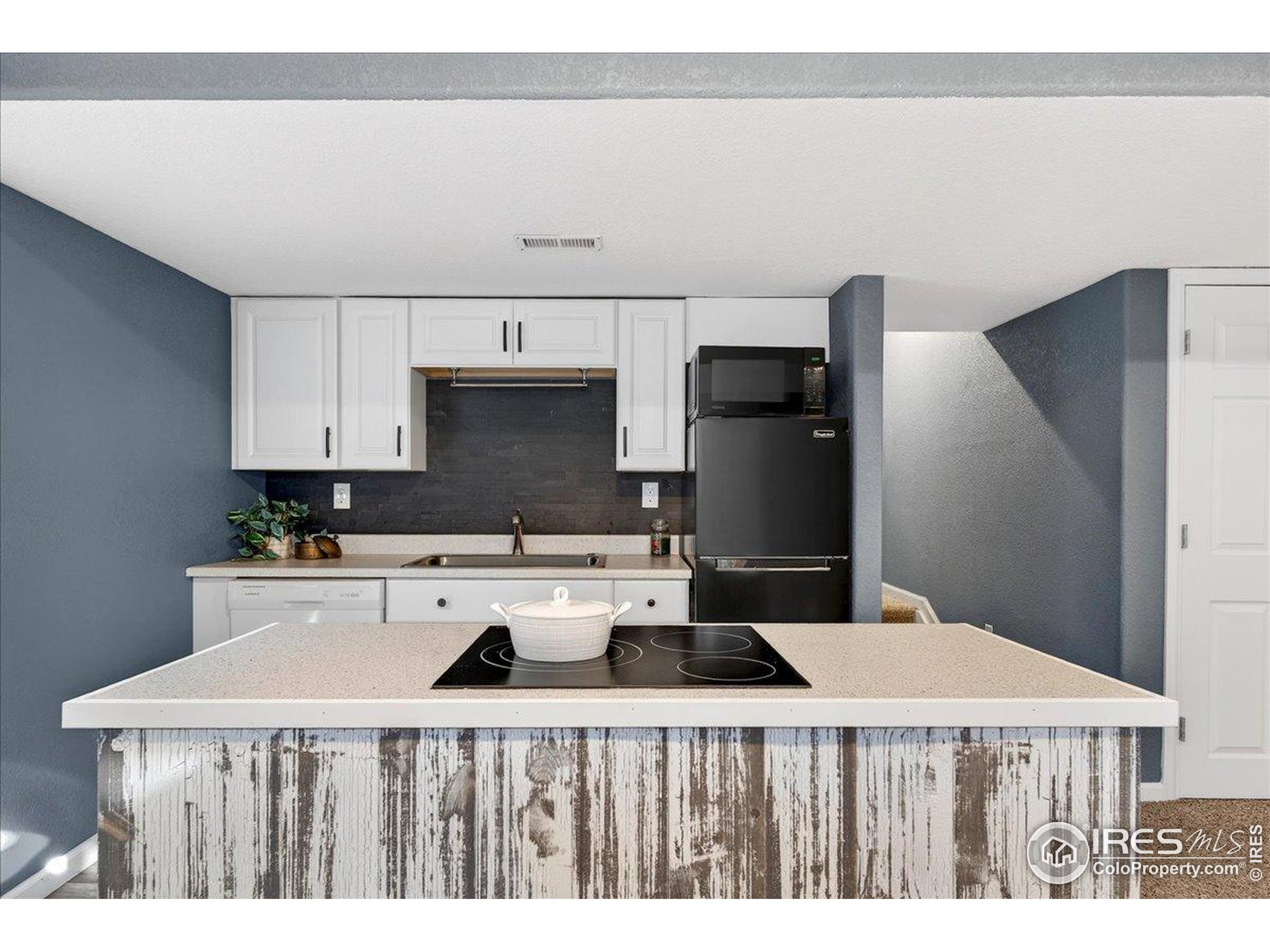 210 Saxony Road Johnstown, CO 80534 - Photo 22 of 34 a kitchen with a stove a refrigerator and a cabinets