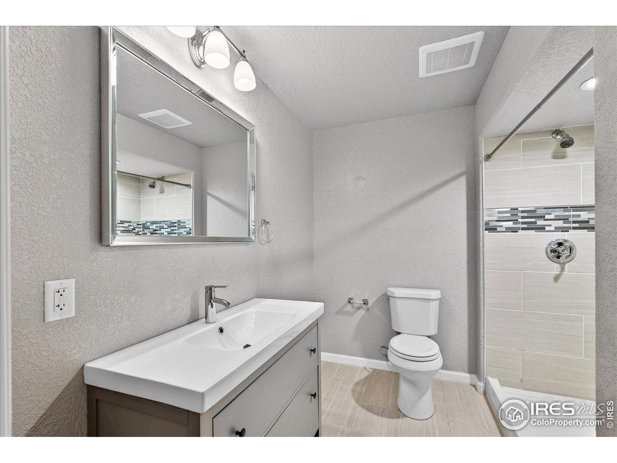 210 Saxony Road Johnstown, CO 80534 - Photo 23 of 34 a bathroom with a toilet a sink and mirror