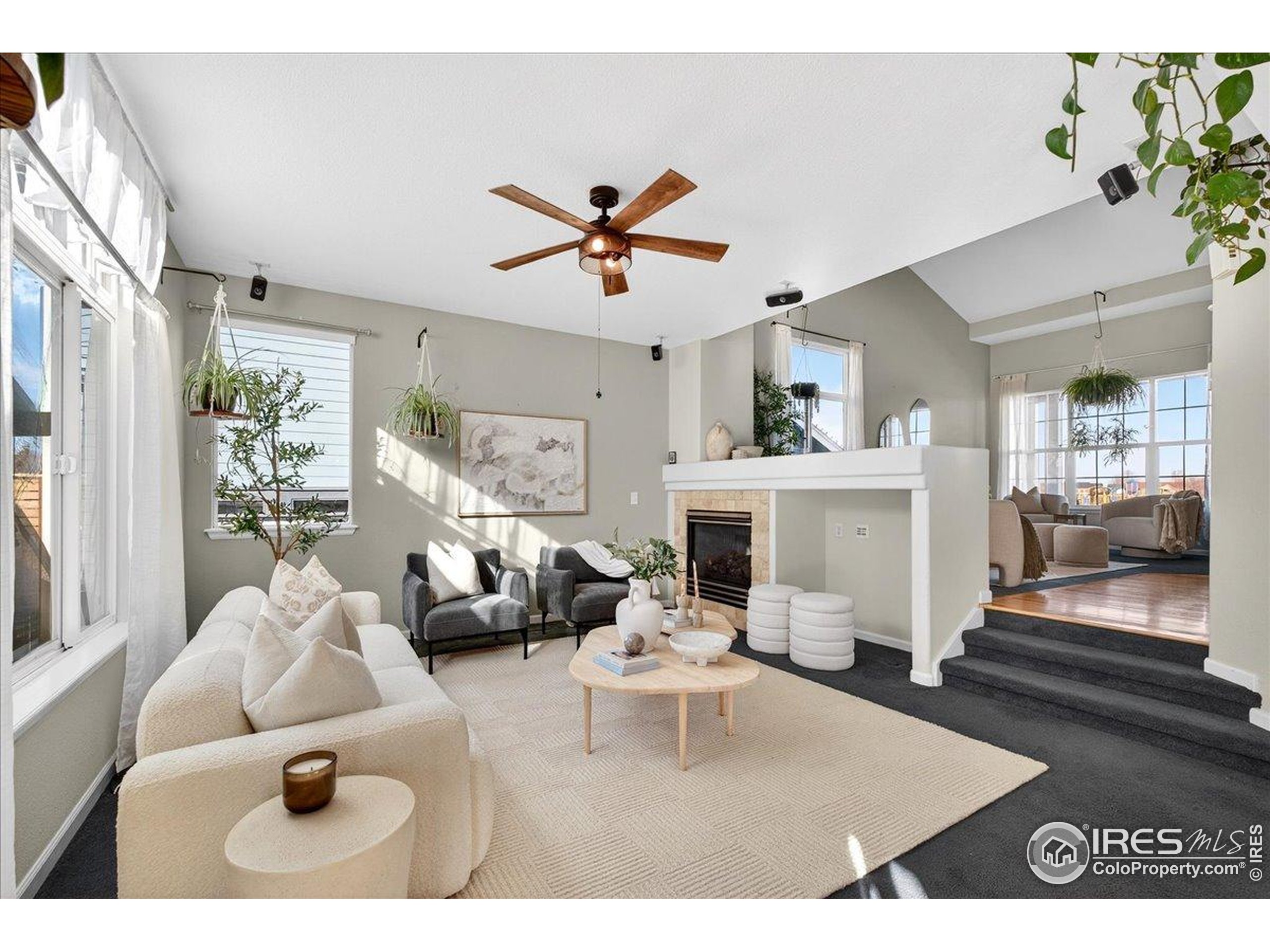 210 Saxony Road Johnstown, CO 80534 - Photo 3 of 34 a living room with furniture a fireplace and a chandelier