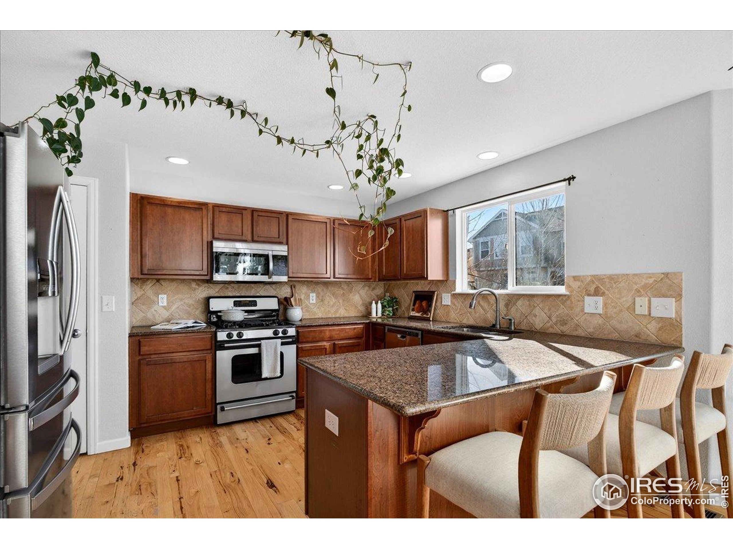 210 Saxony Road Johnstown, CO 80534 - Photo 8 of 34 a kitchen with stainless steel appliances granite countertop a sink a stove and refrigerator