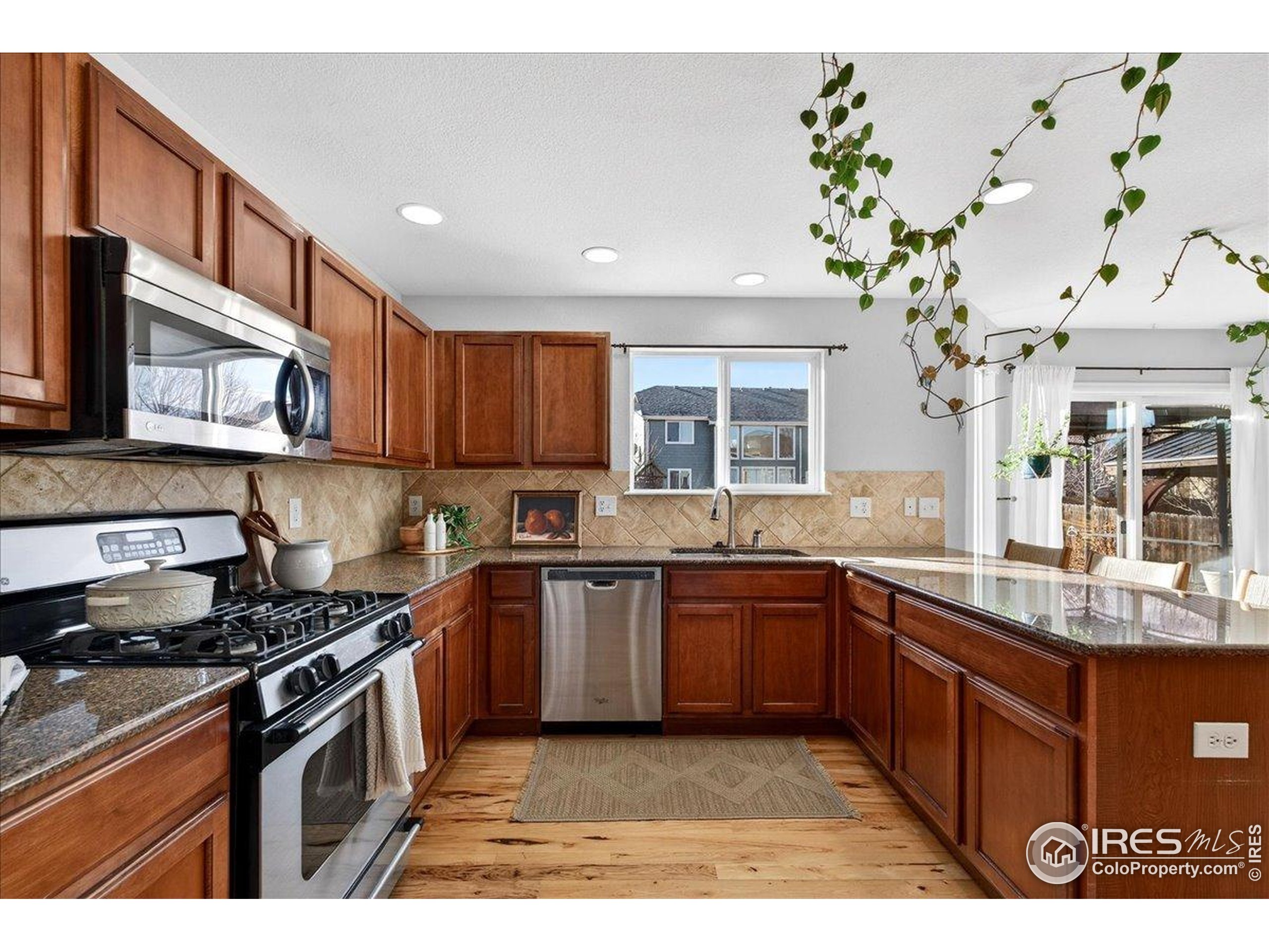 210 Saxony Road Johnstown, CO 80534 - Photo 10 of 34 a kitchen with stainless steel appliances granite countertop a sink a stove top oven a counter space and cabinets