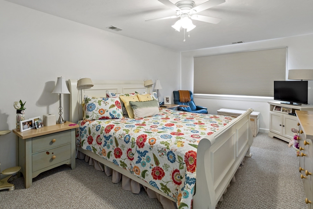 8 Chippers Lane, Unit 390 Mashpee, MA 02649 - Photo 18 of 38 a bedroom with a bed and a chandelier