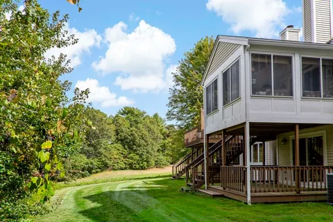 a view of small house with yard in front of it