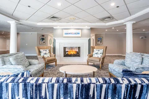 a view of a lake with a bench and chairs