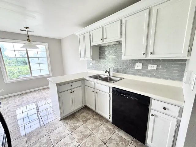 a kitchen with a sink cabinets and window