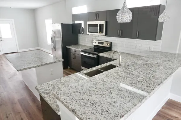 a kitchen with kitchen island granite countertop counter top space cabinets and stainless steel appliances