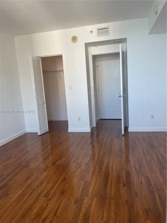 an empty room with wooden floor and closet