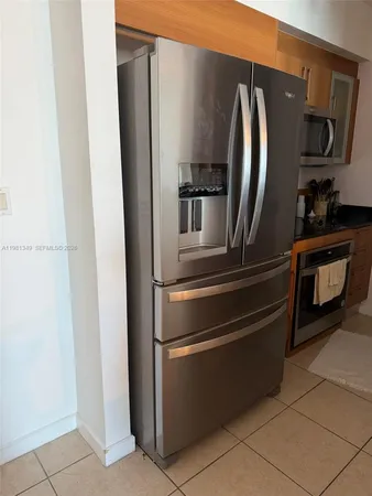a metallic refrigerator freezer sitting in a kitchen