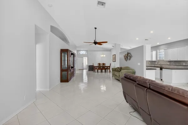 a kitchen with stainless steel appliances granite countertop a refrigerator a sink and white cabinets