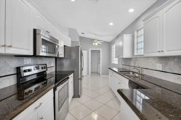 a kitchen with granite countertop a stove sink and cabinets