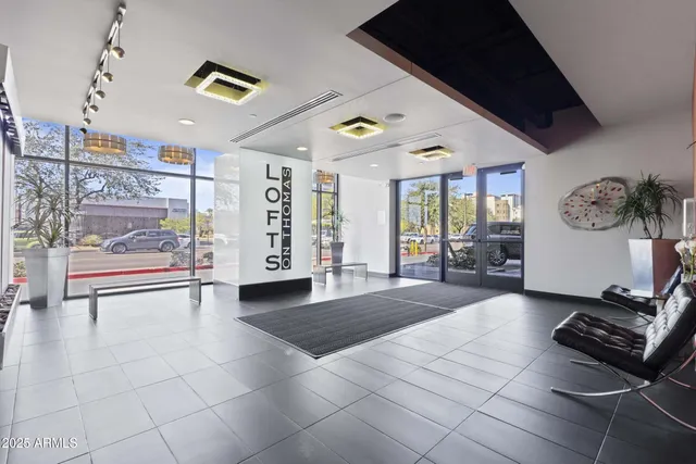 a view of an empty room and a window with the kitchen view