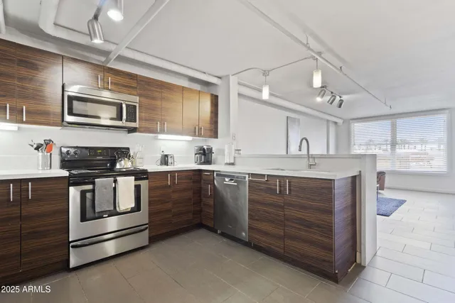 a kitchen with stainless steel appliances granite countertop a stove and cabinets