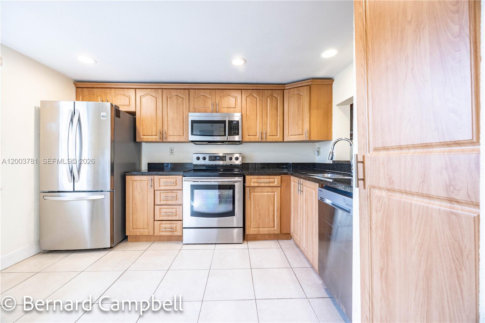 a kitchen with a refrigerator and a stove top oven