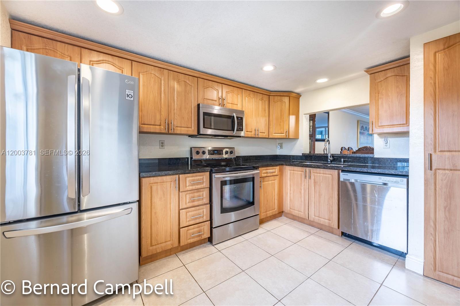 3940 Inverrary Boulevard, Unit 403A Lauderhill, FL 33319 - Photo 4 of 37 a kitchen with stainless steel appliances granite countertop a refrigerator a stove a sink and a microwave