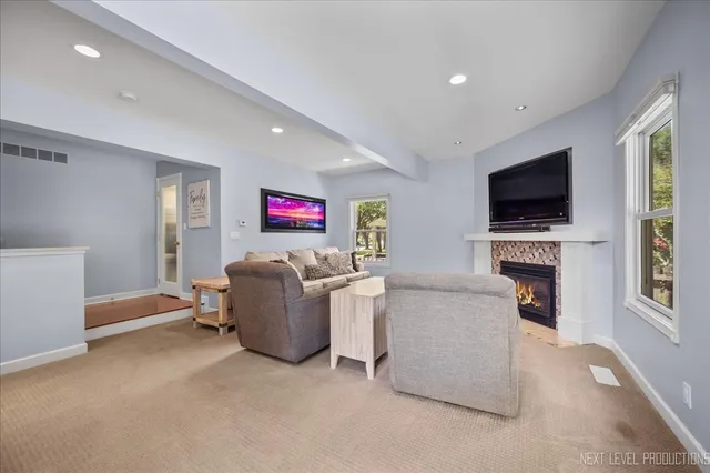 a living room with furniture a fireplace and a flat screen tv