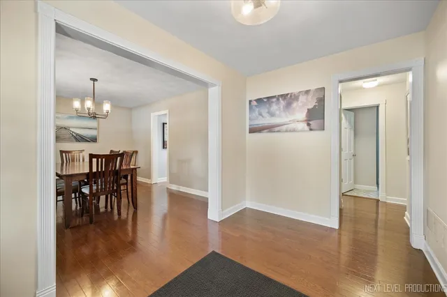 a dining room with wooden floor a glass table and chairs