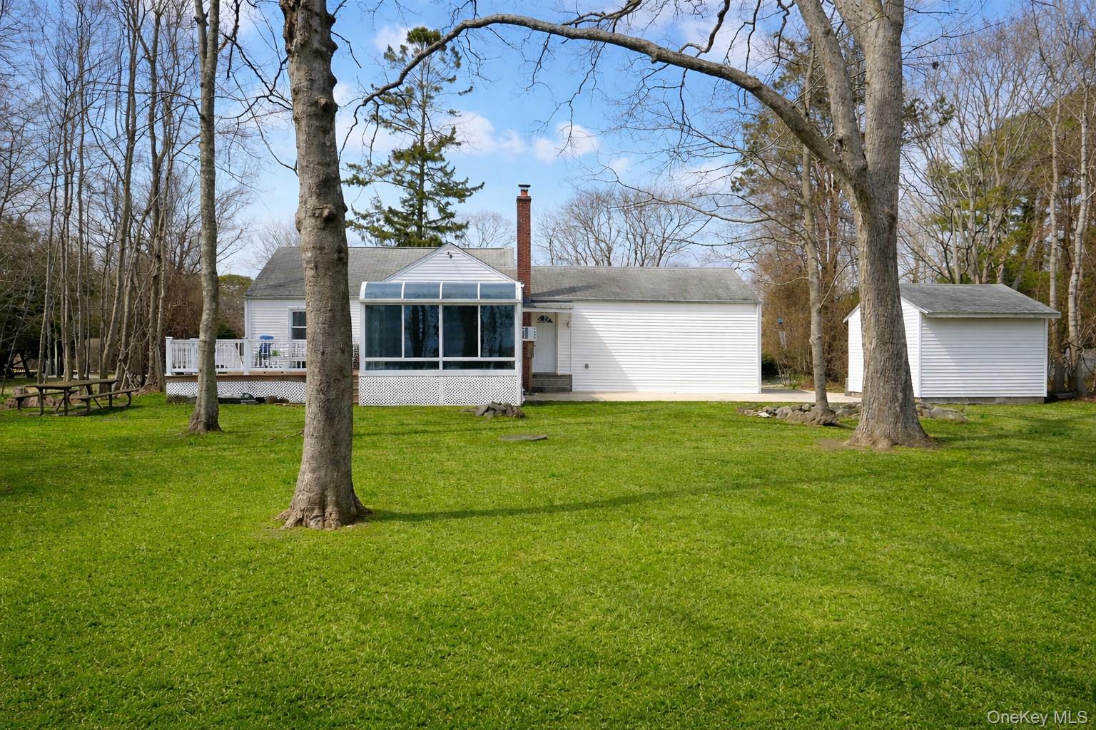 281 Woodacres Road East Patchogue, NY 11772 - Photo 3 of 11 1.25 acre yard with deck and shed, bordering on the Bellport Country Club Golf Course. Green Grass Courtesy of AI.