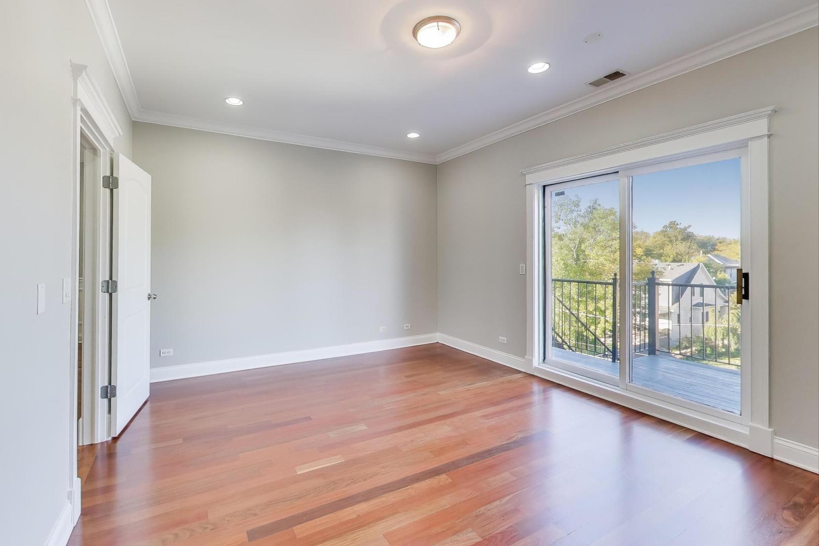 5058 North Kimball Avenue, Unit 4 Chicago, IL 60625 - Photo 12 of 26 an empty room with wooden floor and windows