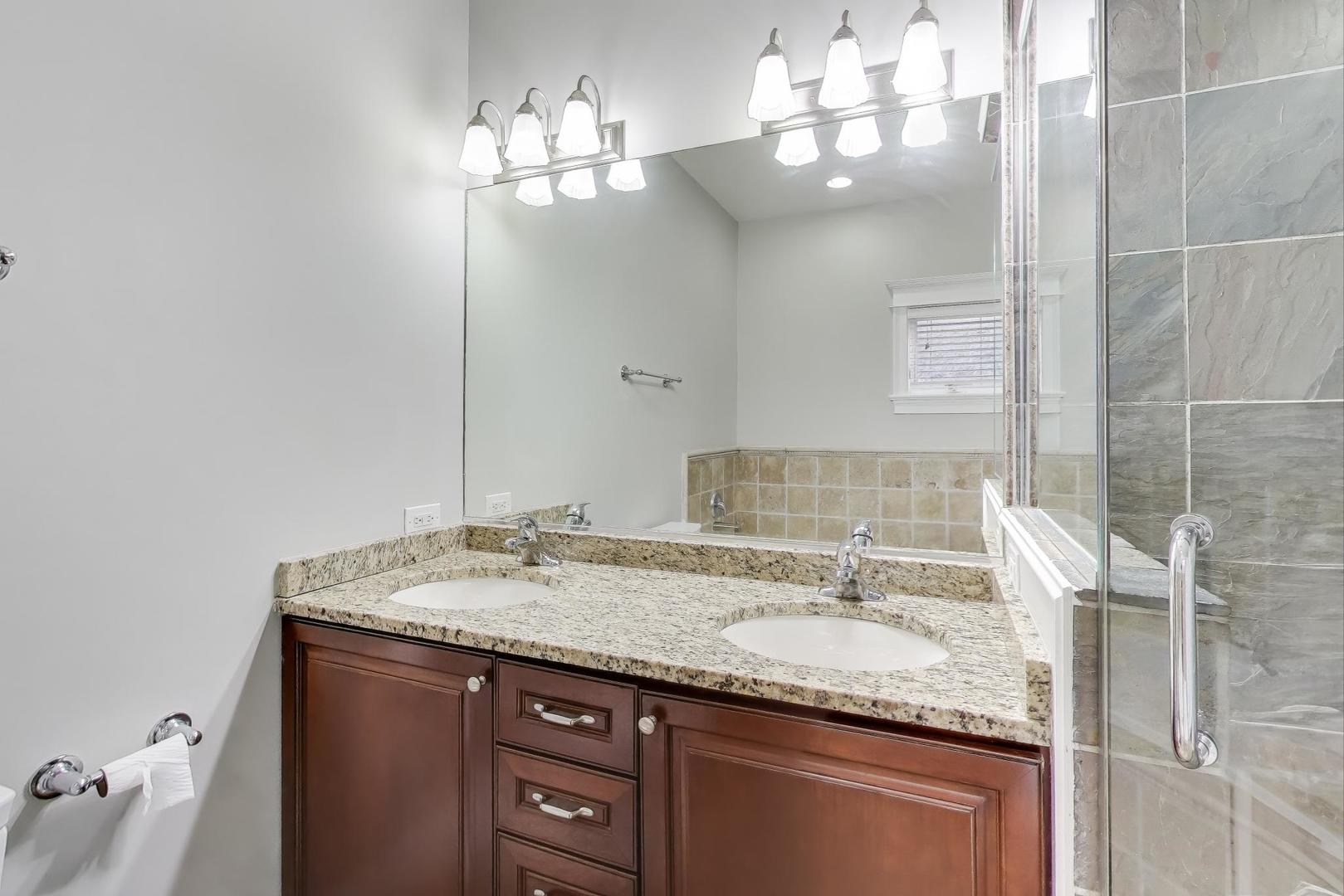 5058 North Kimball Avenue, Unit 4 Chicago, IL 60625 - Photo 17 of 26 a bathroom with a granite countertop sink and a mirror