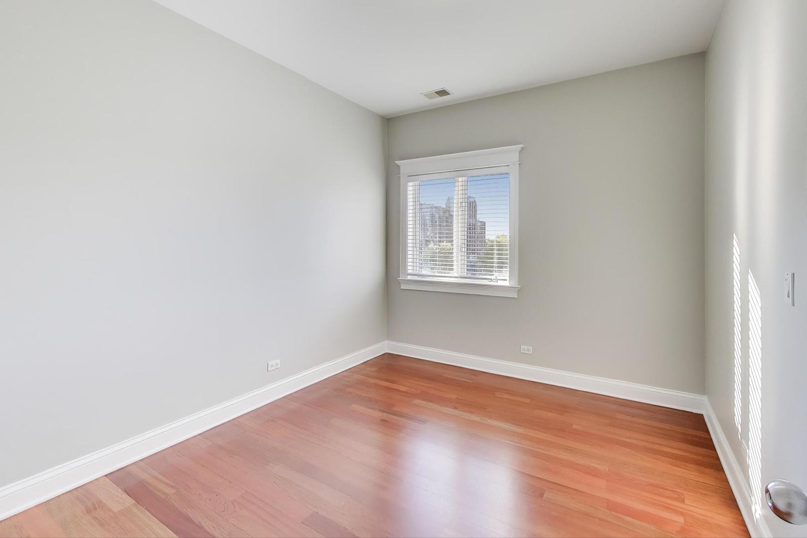 5058 North Kimball Avenue, Unit 4 Chicago, IL 60625 - Photo 19 of 26 a view of an empty room with wooden floor and a window