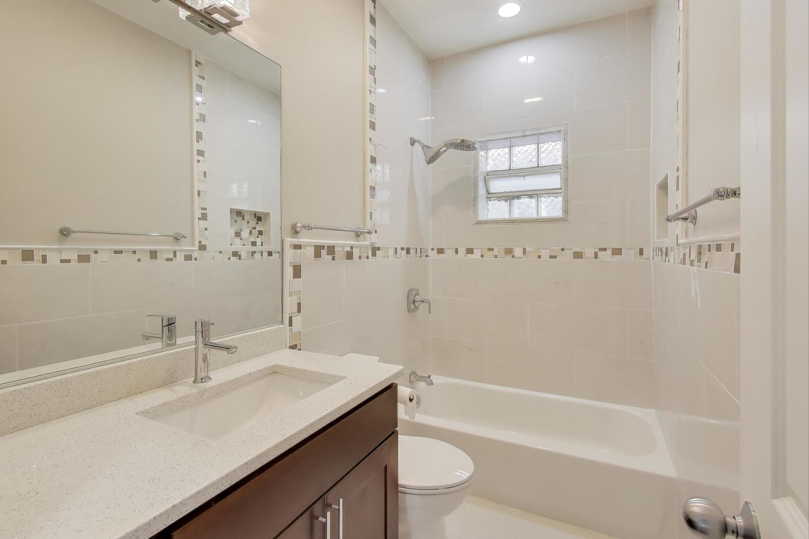 5058 North Kimball Avenue, Unit 4 Chicago, IL 60625 - Photo 20 of 26 a bathroom with a sink a toilet a tub and shower