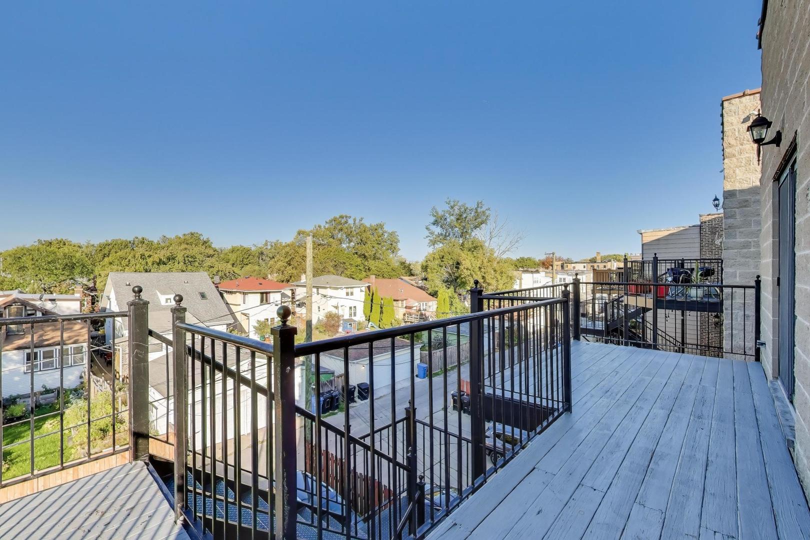 5058 North Kimball Avenue, Unit 4 Chicago, IL 60625 - Photo 24 of 26 a view of a balcony with wooden floor and fence