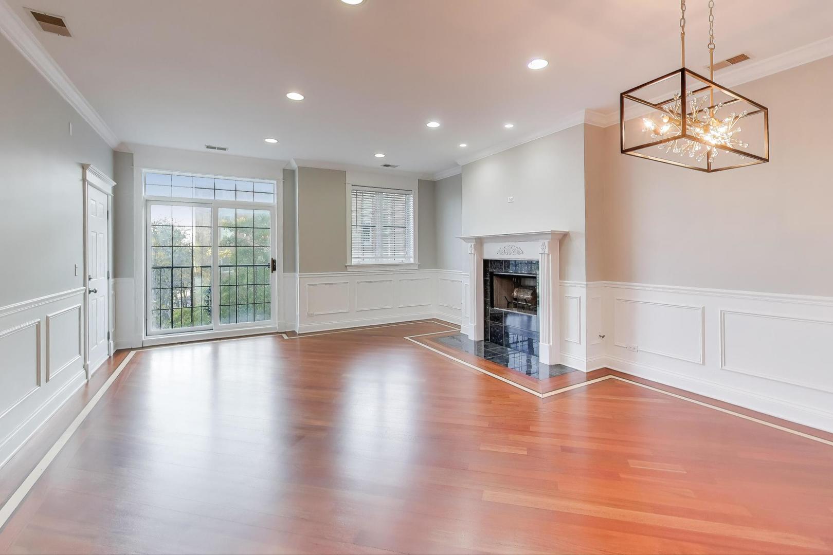 5058 North Kimball Avenue, Unit 4 Chicago, IL 60625 - Photo 5 of 26 an empty room with wooden floor fireplace and windows
