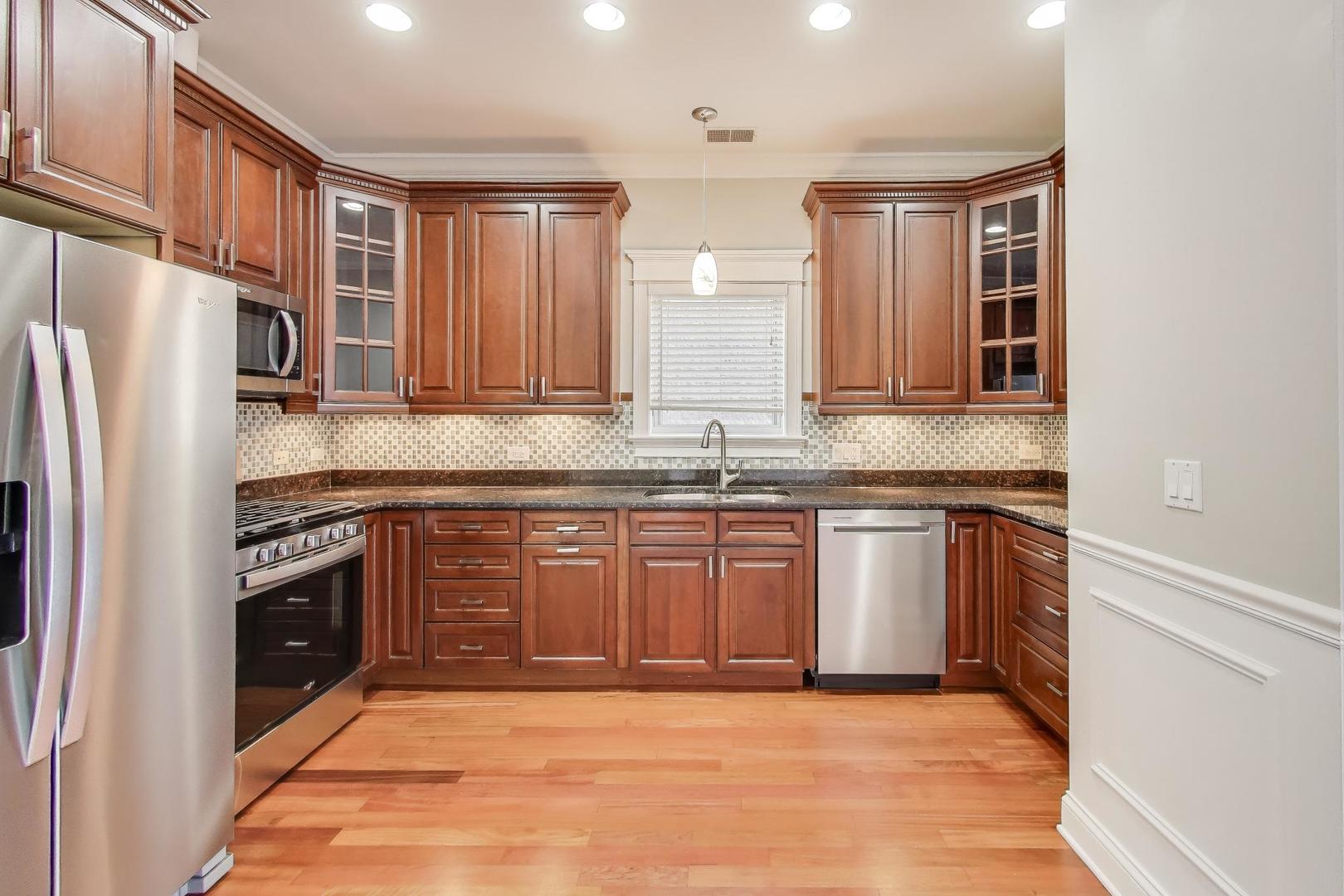 5058 North Kimball Avenue, Unit 4 Chicago, IL 60625 - Photo 7 of 26 a kitchen with stainless steel appliances granite countertop a stove a sink and a refrigerator