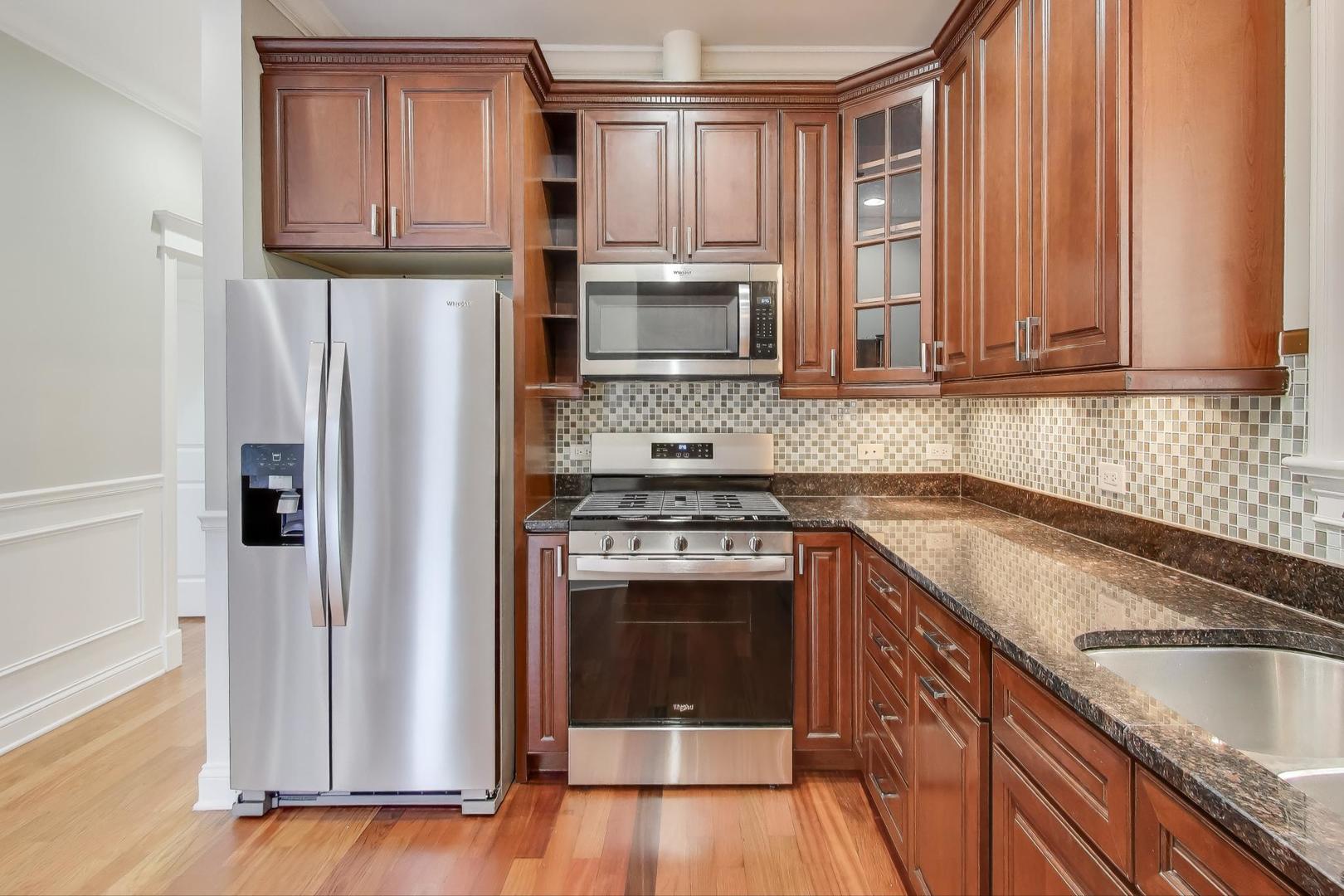 5058 North Kimball Avenue, Unit 4 Chicago, IL 60625 - Photo 8 of 26 a kitchen with stainless steel appliances granite countertop a refrigerator sink and stove