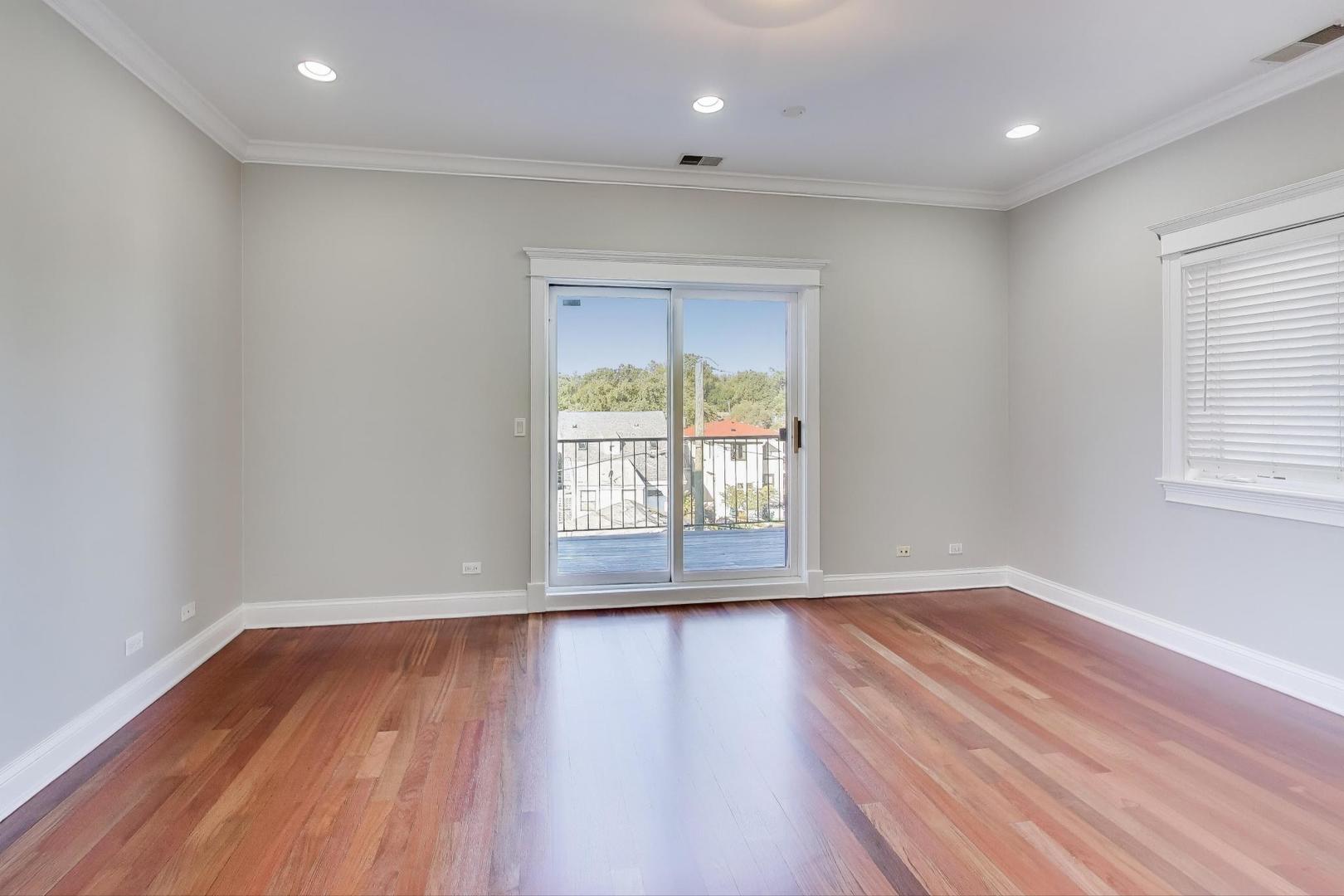 5058 North Kimball Avenue, Unit 4 Chicago, IL 60625 - Photo 10 of 26 an empty room with wooden floor and windows