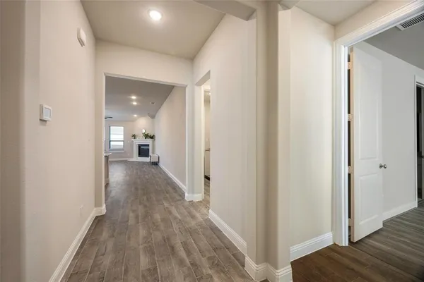 a view of a hallway with wooden floor
