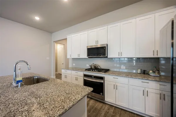a kitchen with white cabinets appliances and a sink