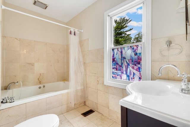 8458 South Constance Avenue Chicago, IL 60617 - Photo 12 of 23 a bathroom with a sink mirror toilet and bathtub