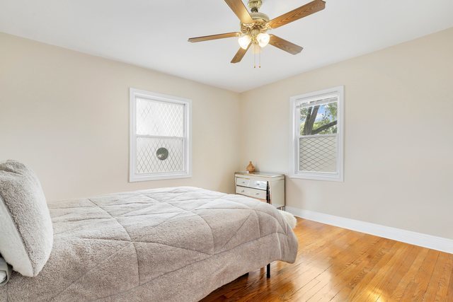 8458 South Constance Avenue Chicago, IL 60617 - Photo 10 of 23 a bedroom with a large bed and a chandelier