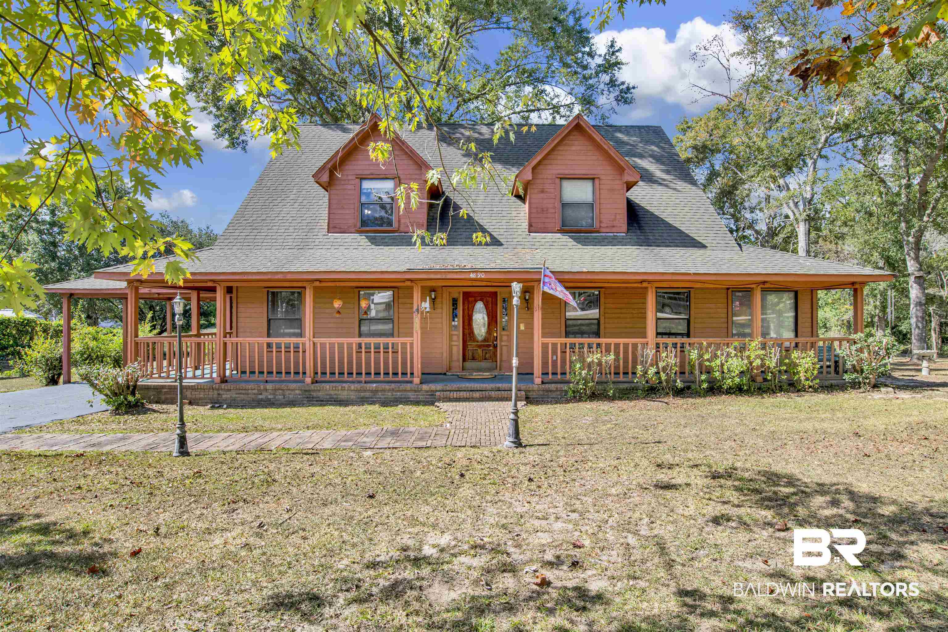 Farmhouse-style home featuring a front yard and covered porch