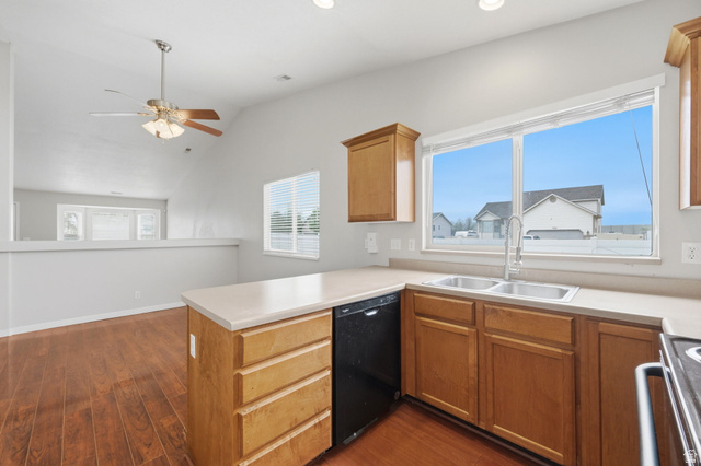 2575 Athena Drive Magna, UT 84044 - Photo 7 of 23 Kitchen featuring wood-finish flooring, light-toned countertops, and wood cabinetry