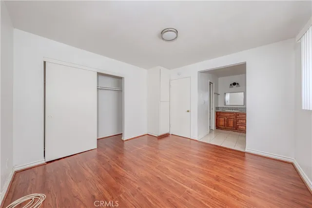 a kitchen with stainless steel appliances kitchen island granite countertop a table chairs in it and wooden floors