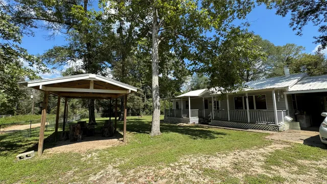 a view of a patio with table and chairs under an umbrella