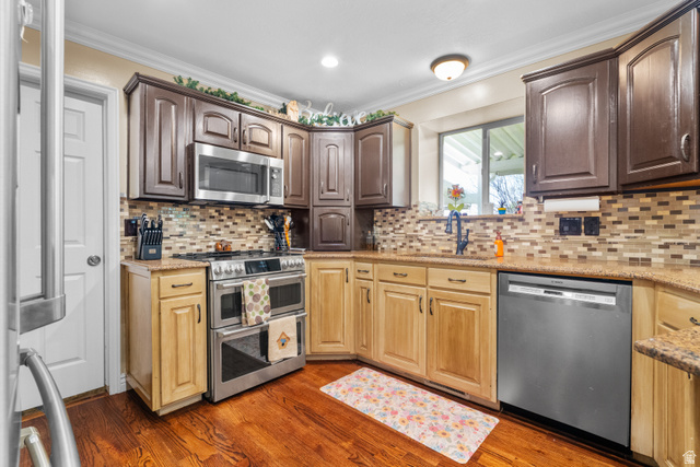 5727 South 3550th Street West Roy, UT 84067 - Photo 21 of 49 Kitchen featuring hardwood flooring, two-tone cabinetry, stainless steel appliances, a mosaic tile backsplash, and granite countertops