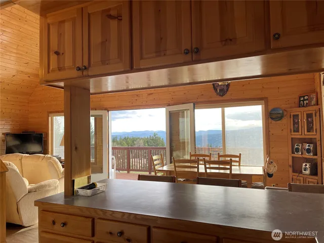 a kitchen with a large window cabinets and living room view